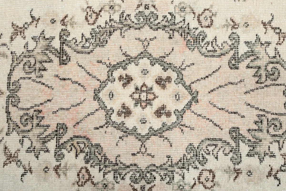 Detailed view of the central floral medallion pattern on the vintage rug