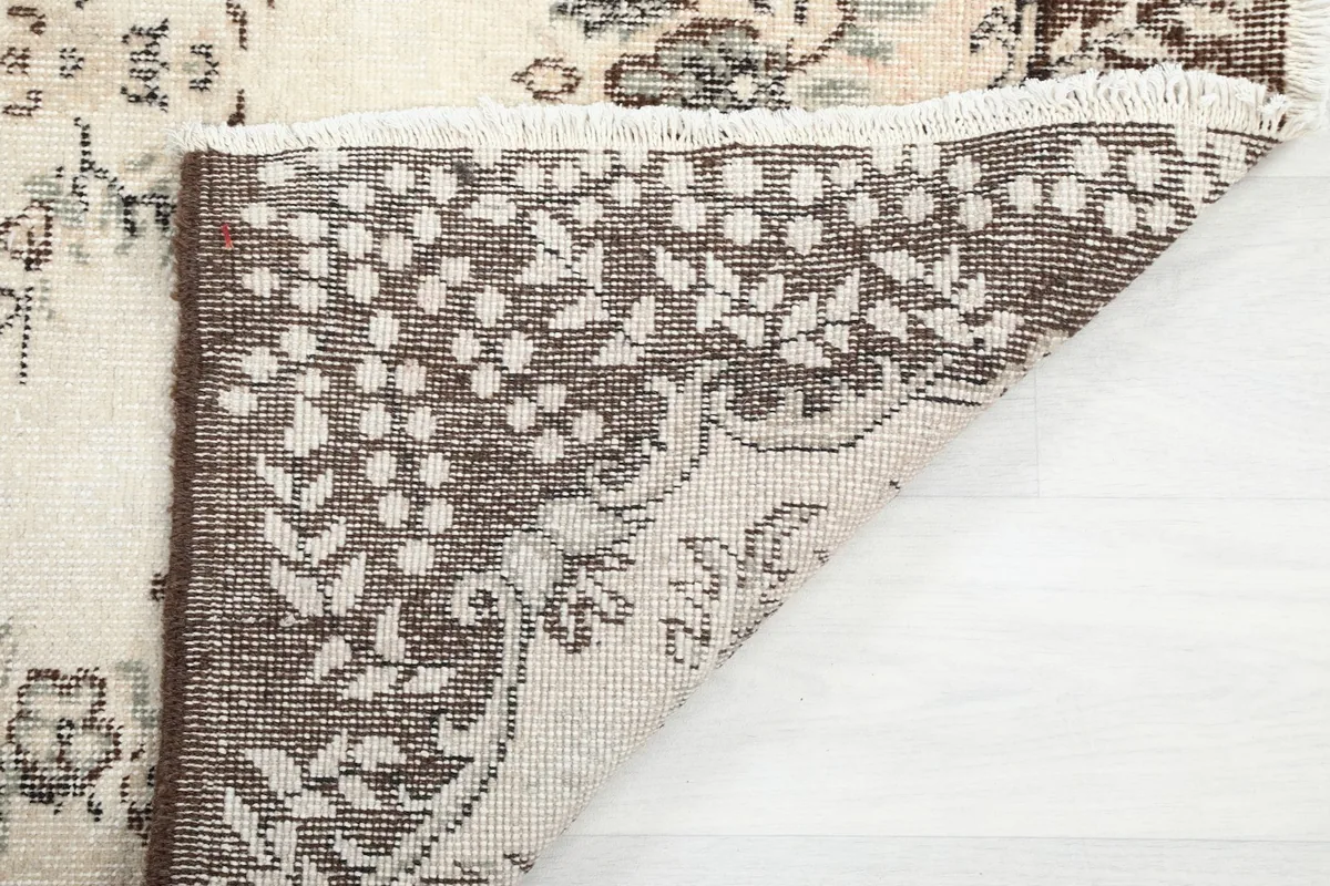 Underside of the rug revealing the hand-knotted cotton foundation and fringe