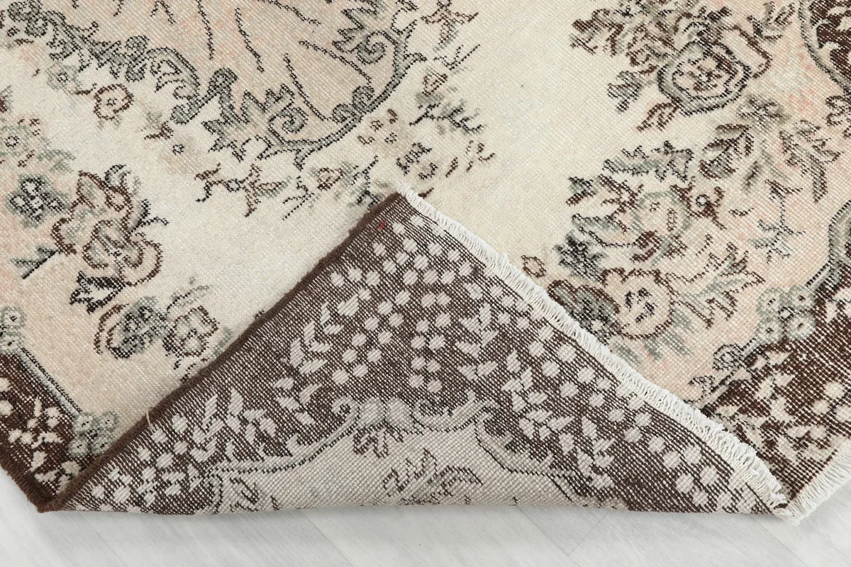 Folded corner of the rug showing the wool pile and cotton foundation