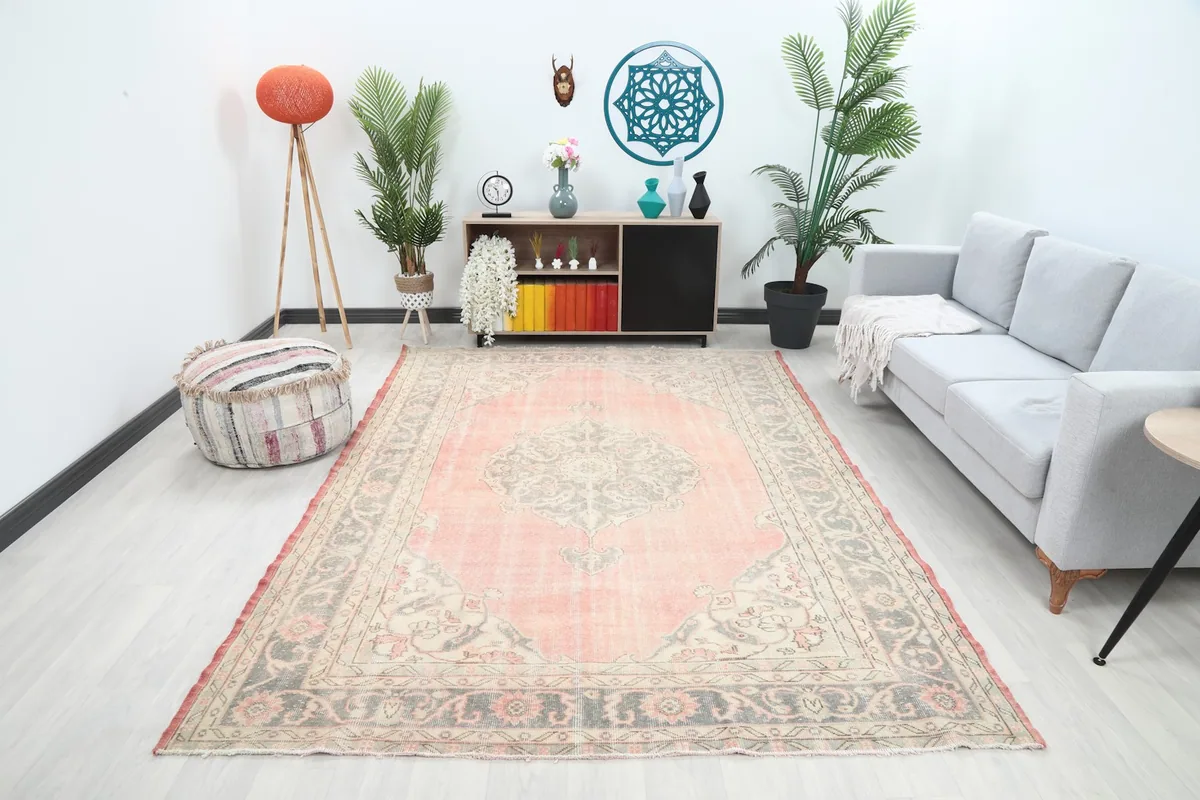 Vintage area rug with rose field and gray motifs in a modern living room setting