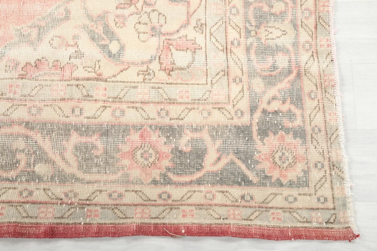 Detail of the gray and ivory border with floral accents on the vintage rug
