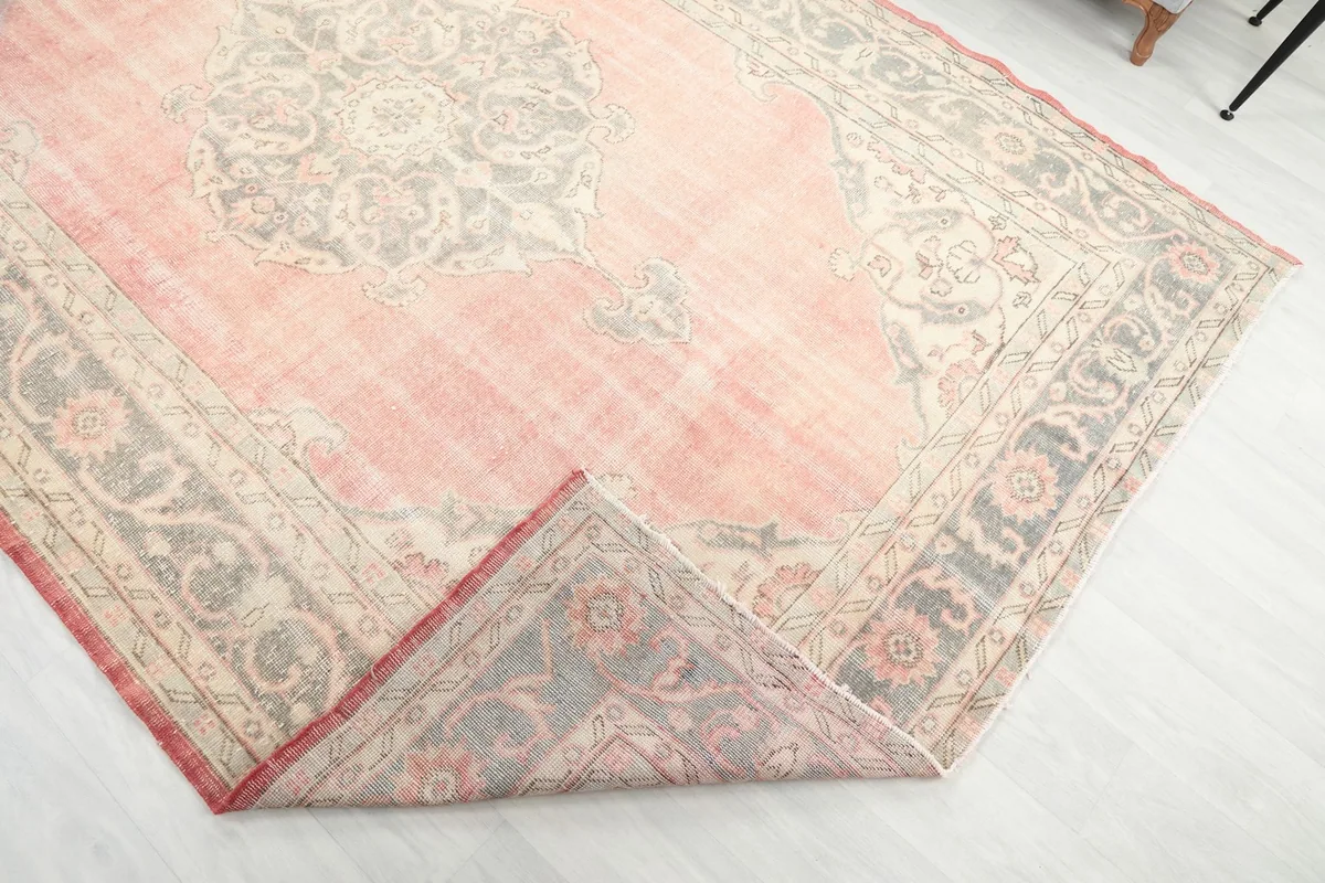 Corner of the rug folded back, revealing the hand-knotted wool pile and cotton foundation