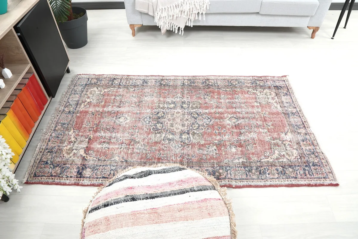 Wide shot of the red vintage area rug in a room, showcasing its small size and placement