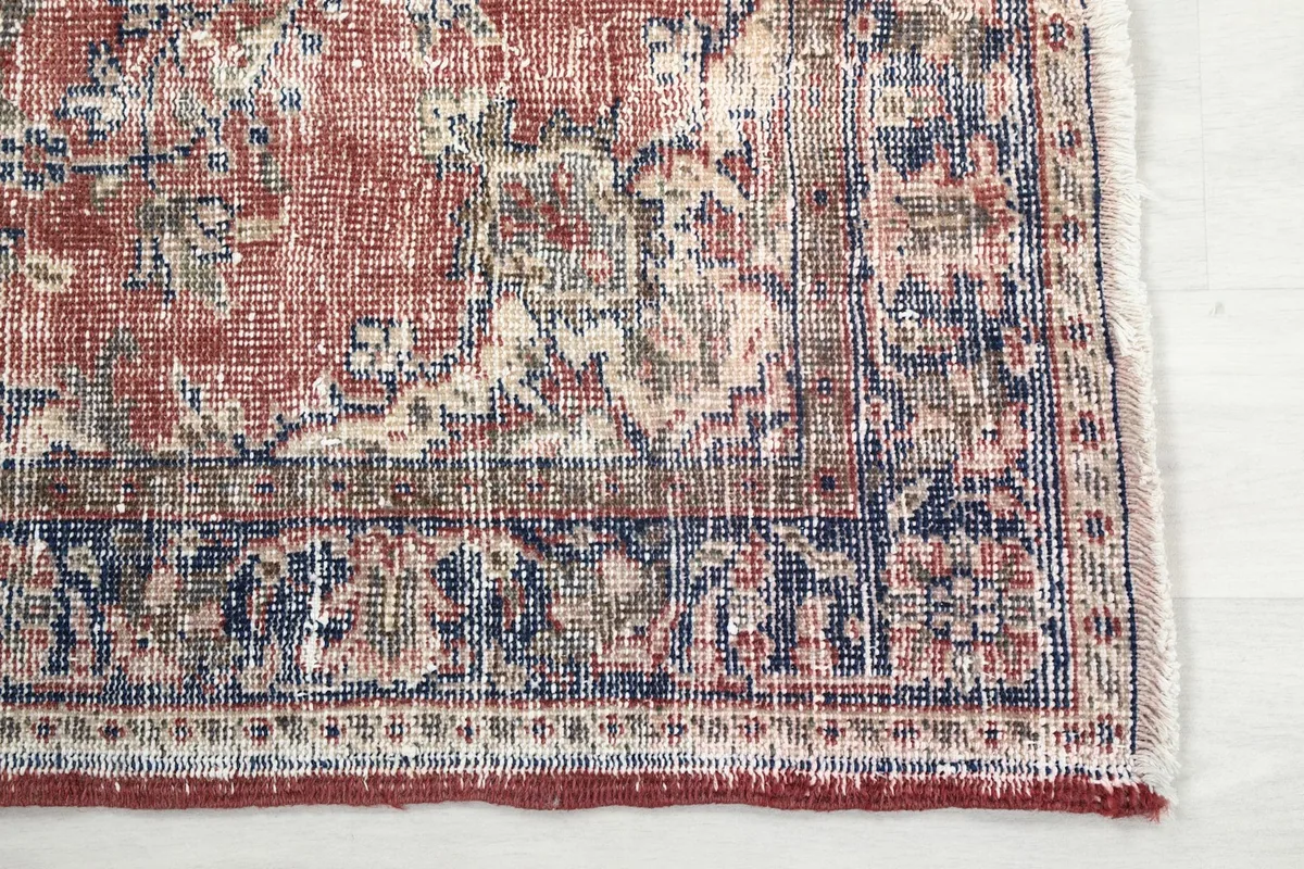Detailed view of the rug's navy border and corner, showing the hand-knotted texture