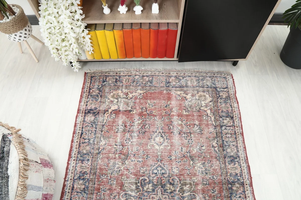 Overhead perspective of the red and navy vintage rug in a room, capturing its full design