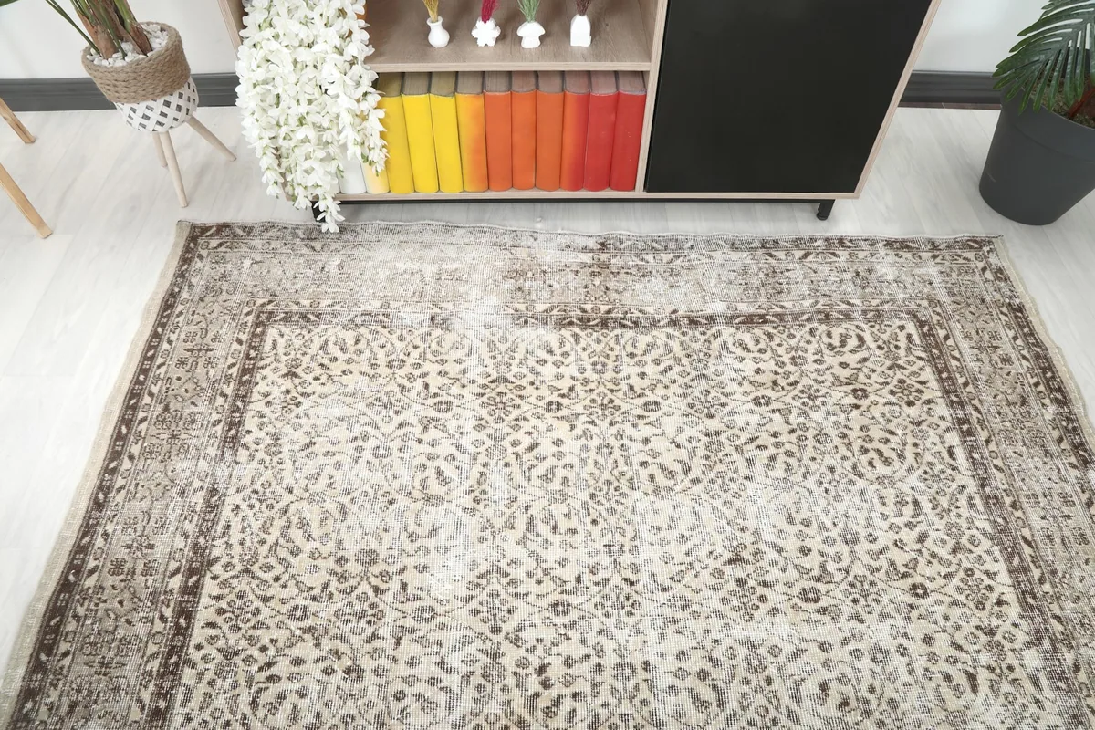Overhead view of the rug in a room setting, capturing its full pattern and distressed appearance.