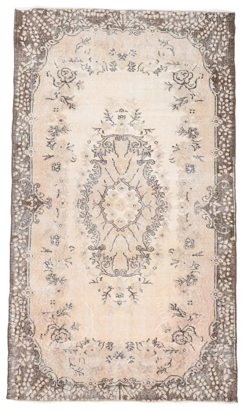 Full overhead view of the beige and brown floral vintage Anatolian area rug