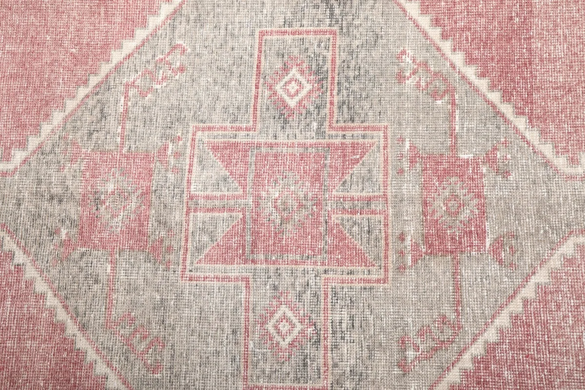 Extreme close-up of the intricate tribal motifs within a gray medallion