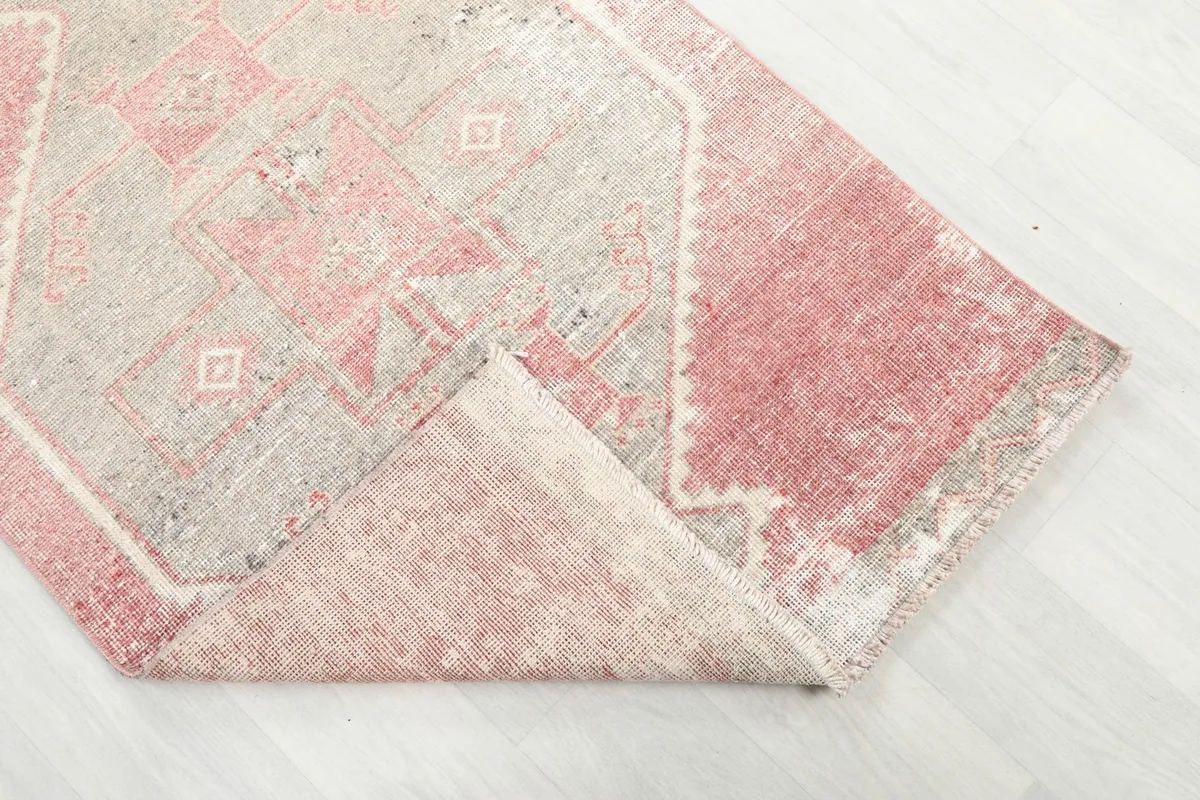 Corner of the runner folded back, revealing the wool pile and cotton foundation