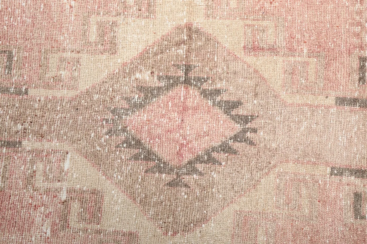 Detailed shot of a central diamond motif with tribal elements in gray and beige