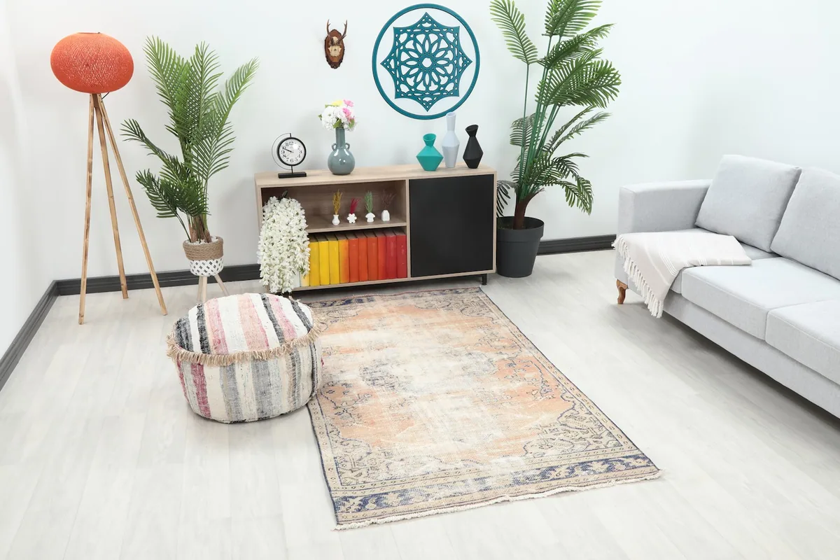 Angle view of the rust and blue vintage rug in a living room, showing its placement relative to furniture.