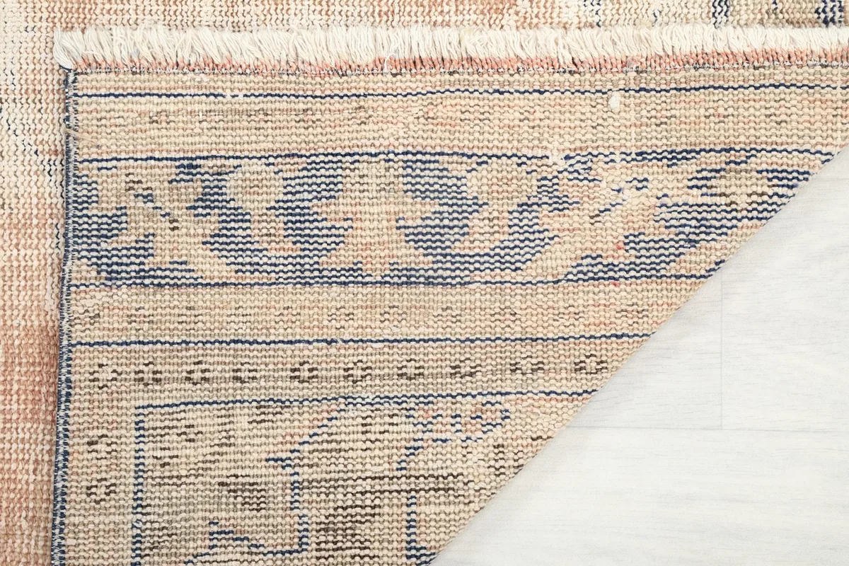 Underside view of the rug, revealing the tightly woven cotton foundation and hand-knotted construction.