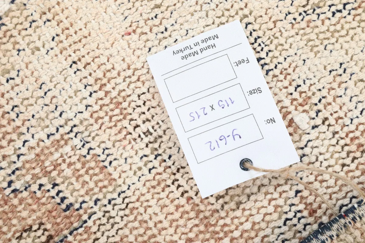 Close-up of the rug's back with a tag showing its size and origin, confirming hand-made quality.