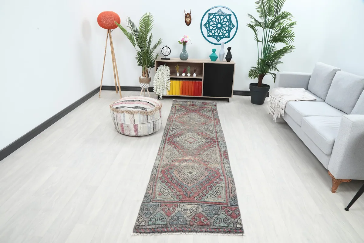 Vintage Anatolian runner rug displayed in a modern living space with a sofa and plants