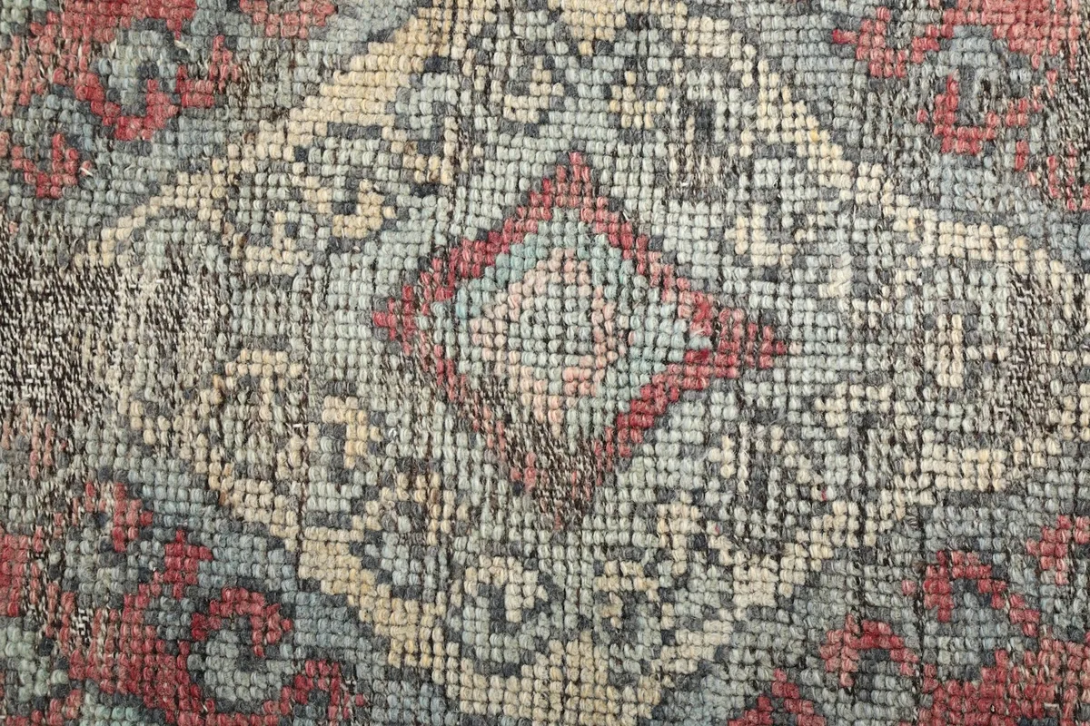 Extreme close-up showing the hand-knotted wool pile and intricate details of the pattern