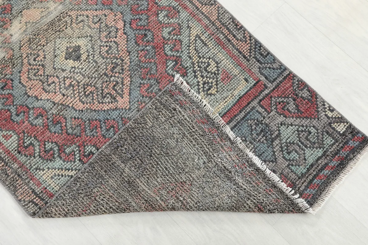 Corner of the runner rug folded to show the hand-knotted cotton foundation on the reverse side