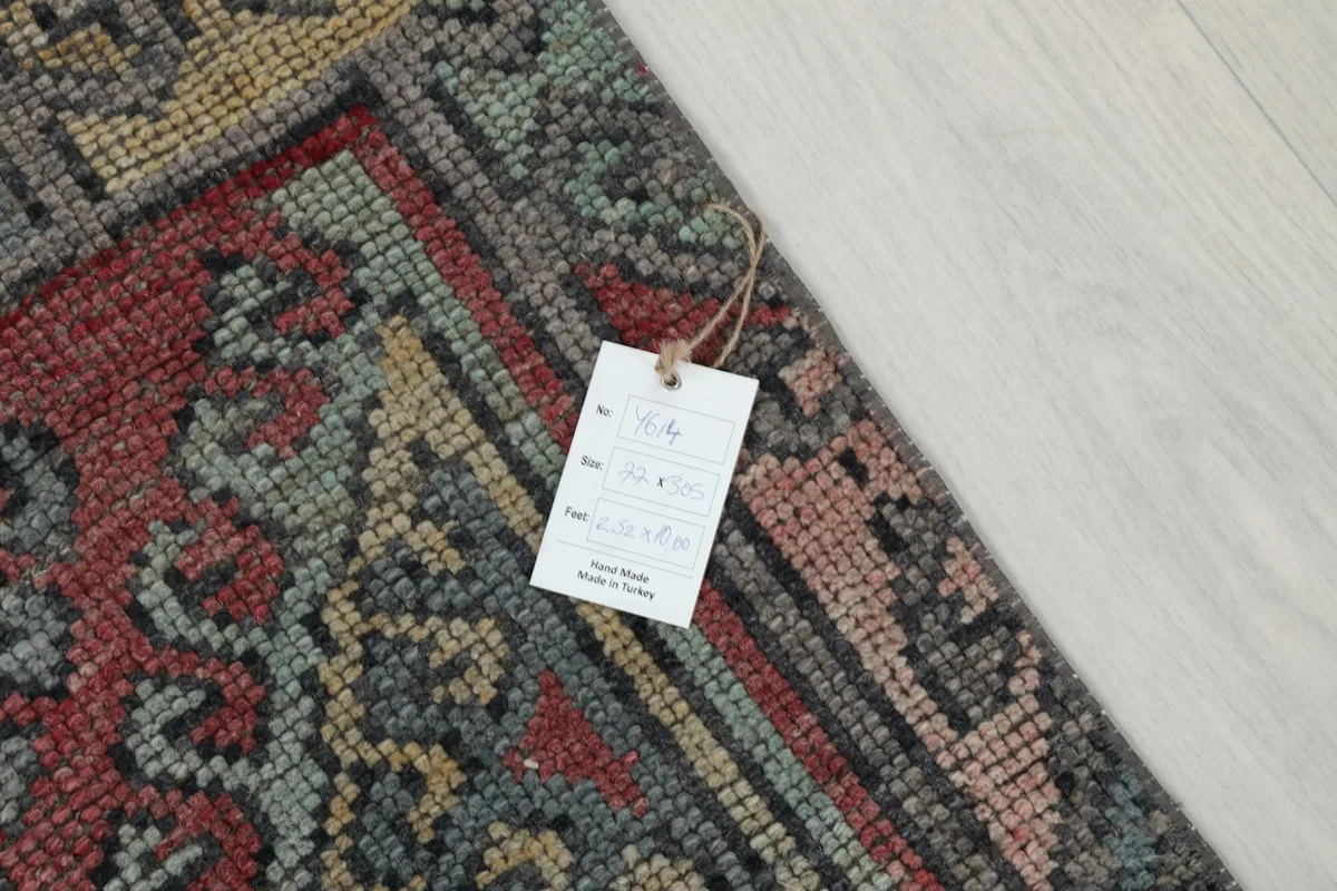 Detail shot of the rug's corner with the product tag, showing the hand-knotted texture