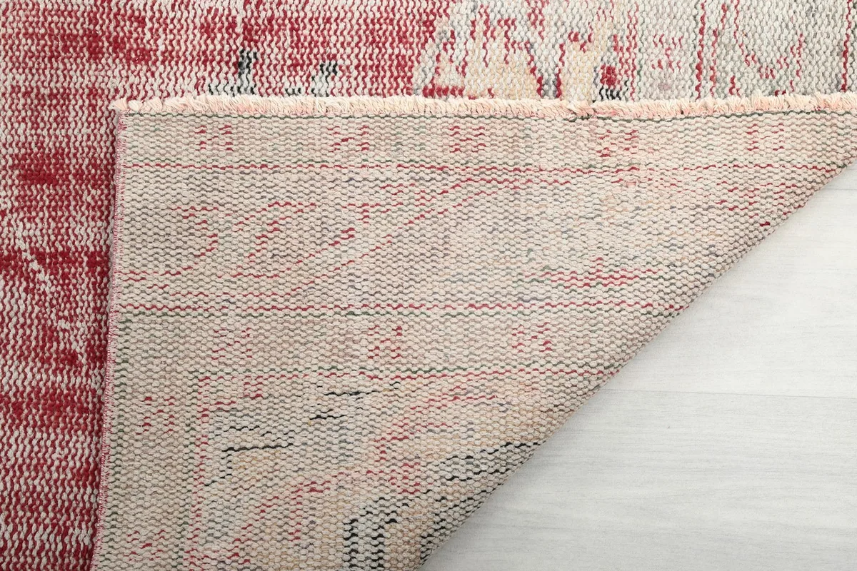 Close-up of the rug's reverse side, showing the tight hand-knotting and cotton foundation.