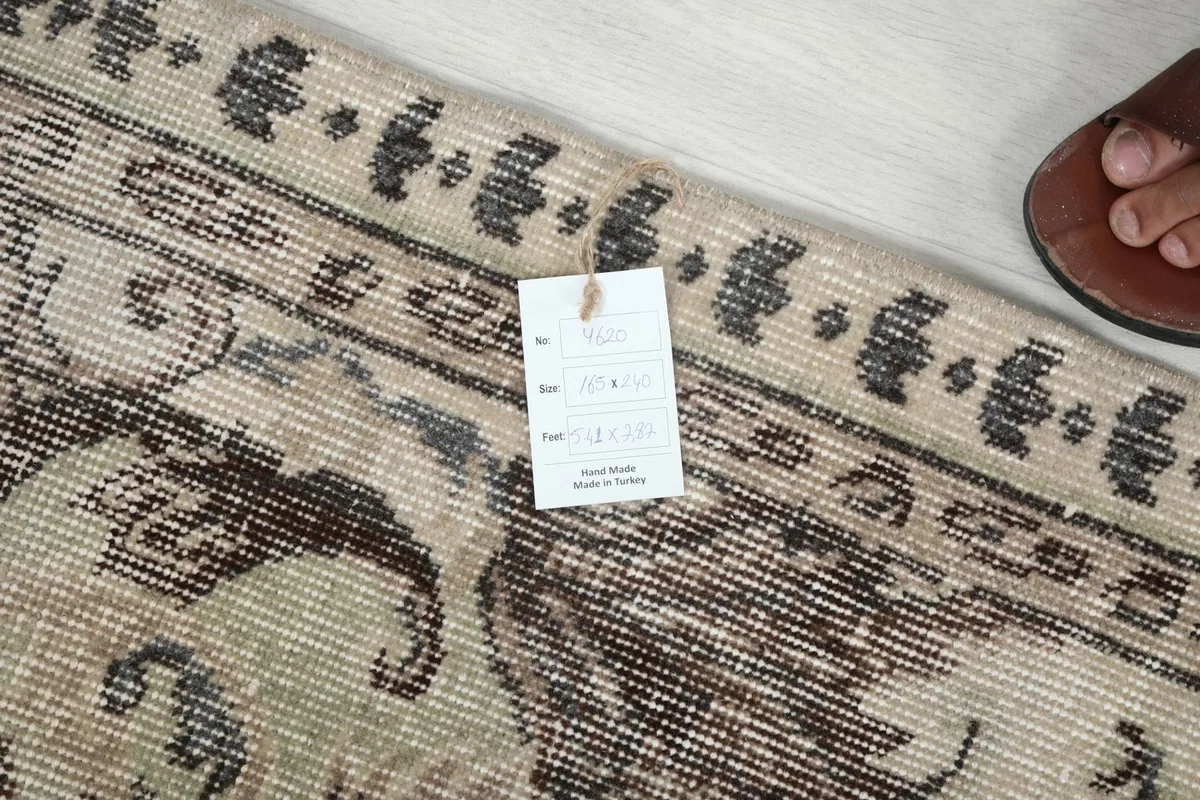 Rug label with details on material, origin, and dimensions, next to the rug's border