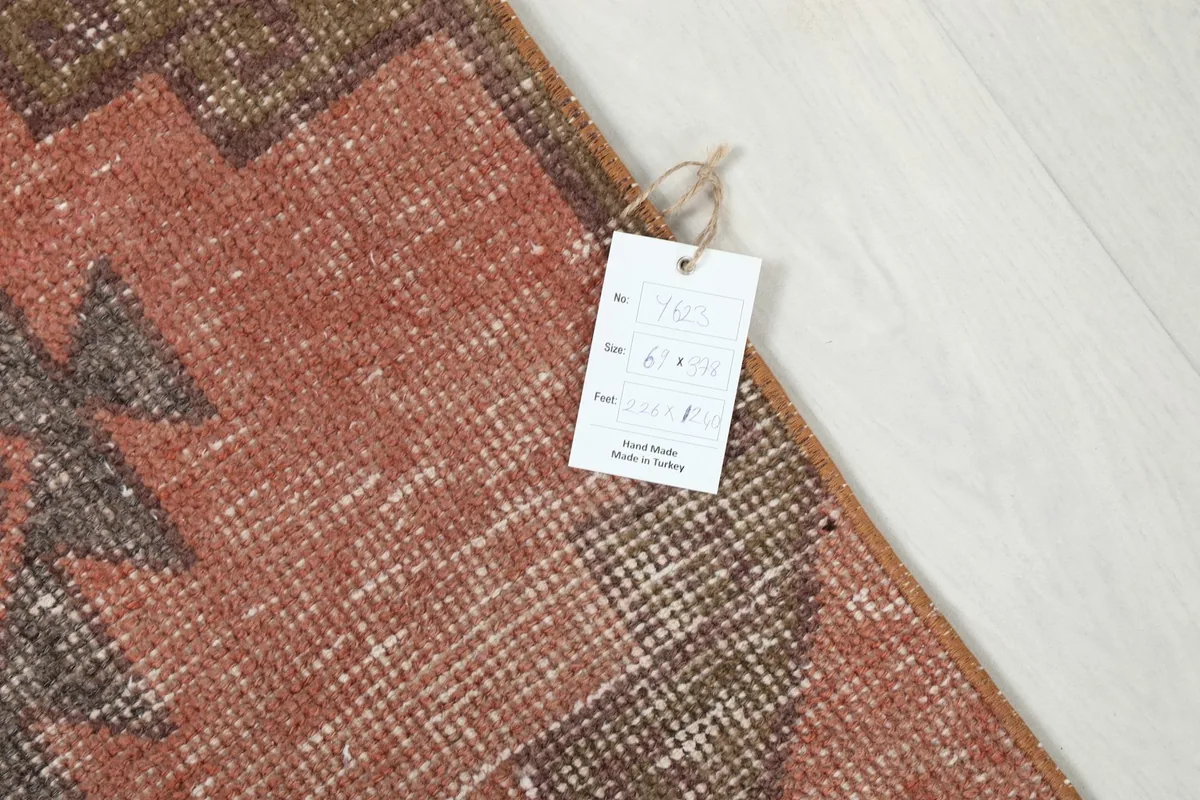 Corner of the runner with a product tag attached, showing the rug's details and origin