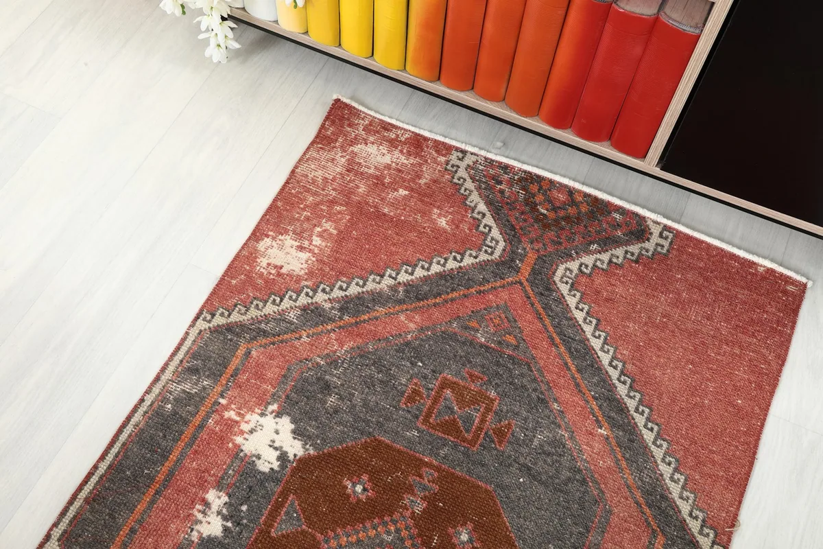 Angled top view highlighting areas of natural wear and color variation on the rug