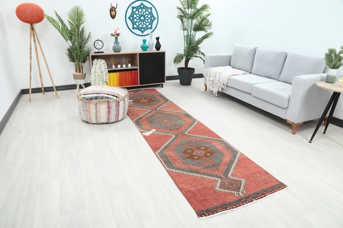 Angle view of the rust and gray geometric runner rug in a bright room setting
