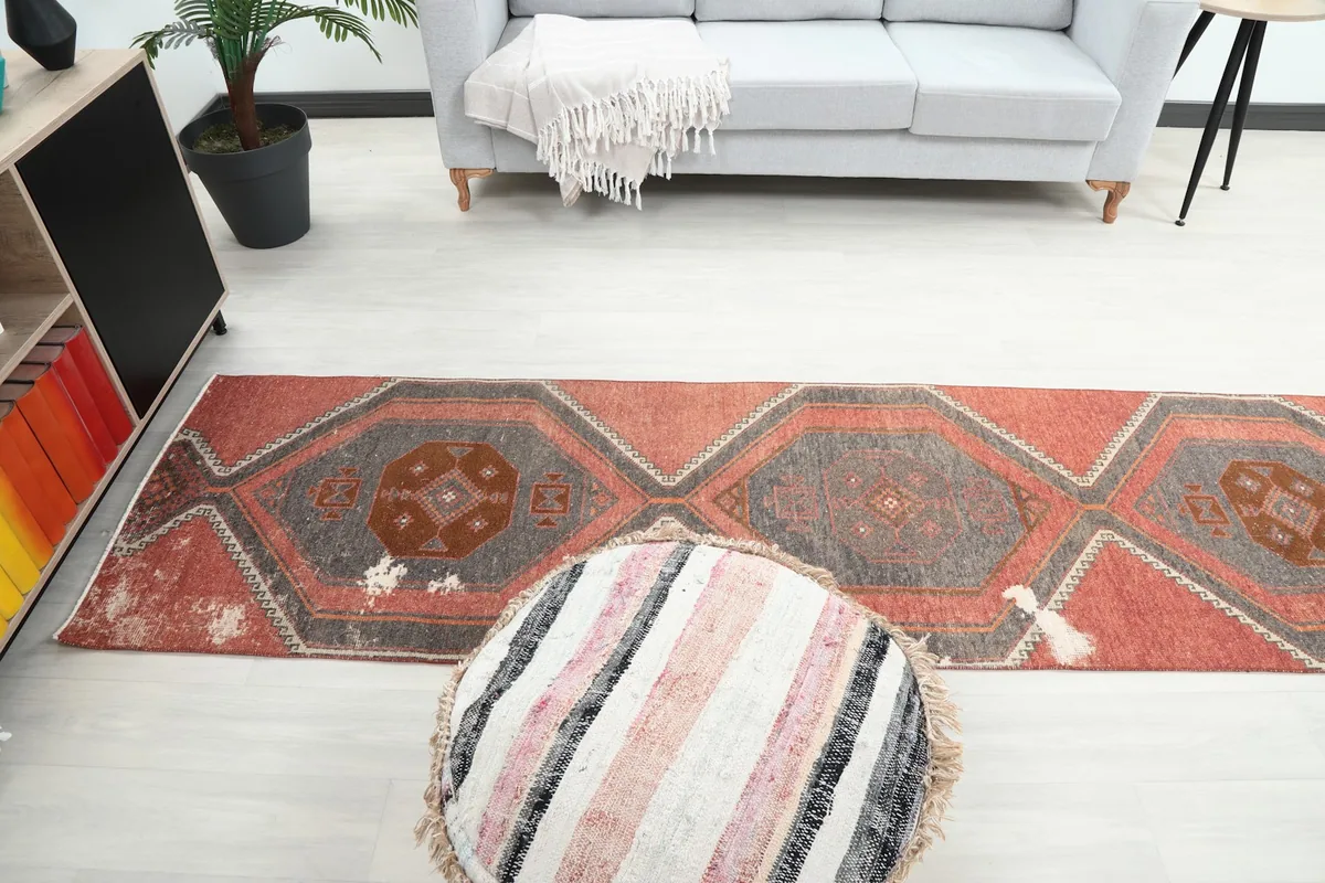 Overhead view of the rug stretching across the floor, with a sofa and pouf