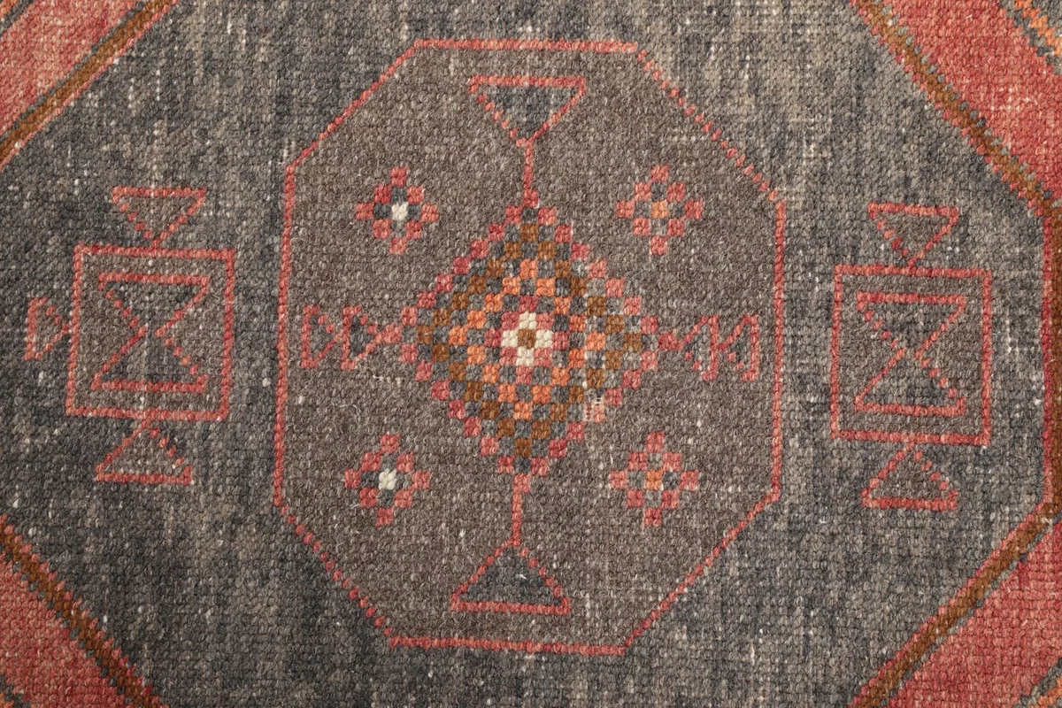 Tight detail of the intricate tribal motifs within a gray medallion