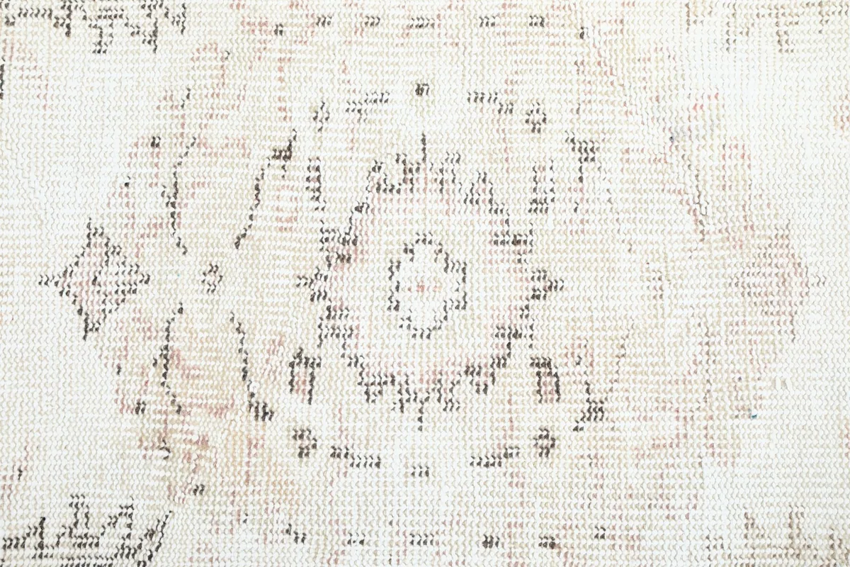 Close-up of the central medallion design showing the intricate, faded wool knots