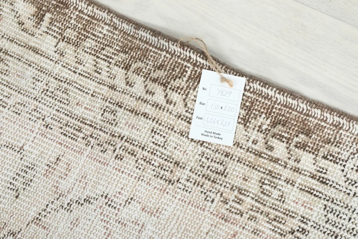 Detail of the rug's edge and a tag indicating its origin and material