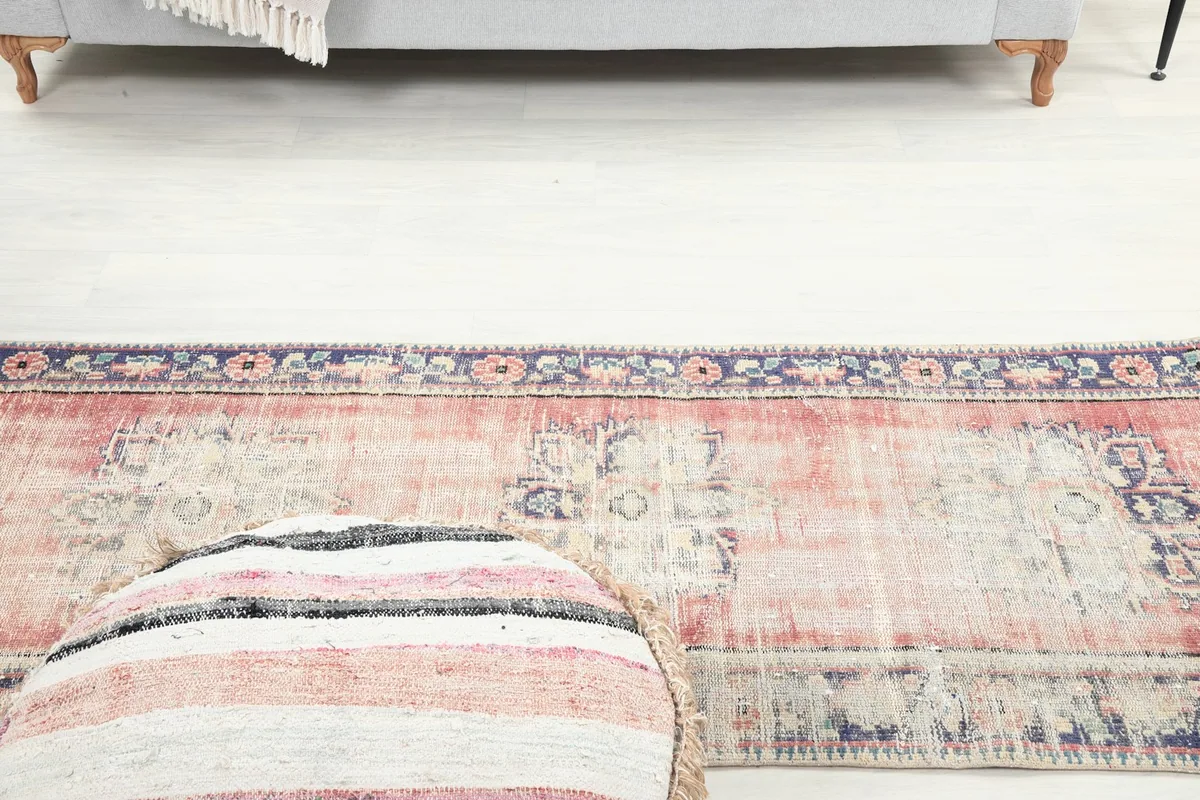 Angle view of the runner rug with a striped pouf in the foreground, showing the full design.