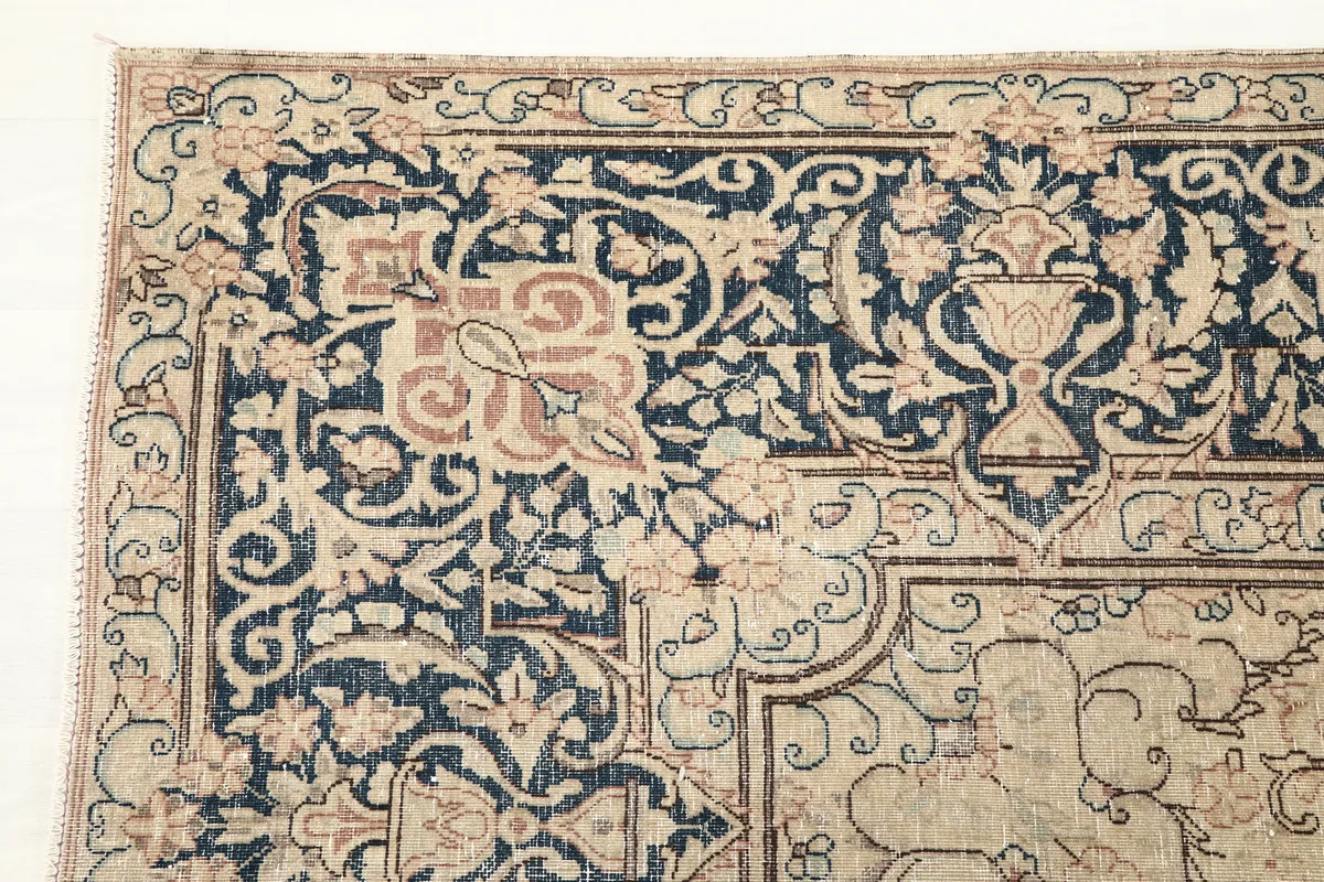 Close-up detail of the Faded Rose Navy Medallion Floral Rug's navy border with intricate floral and scrollwork patterns.