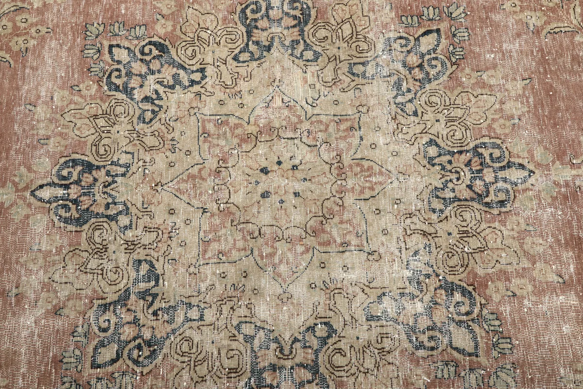 Detailed view of the central medallion on the Faded Rose Navy Medallion Floral Rug, showing faded colors and motifs.