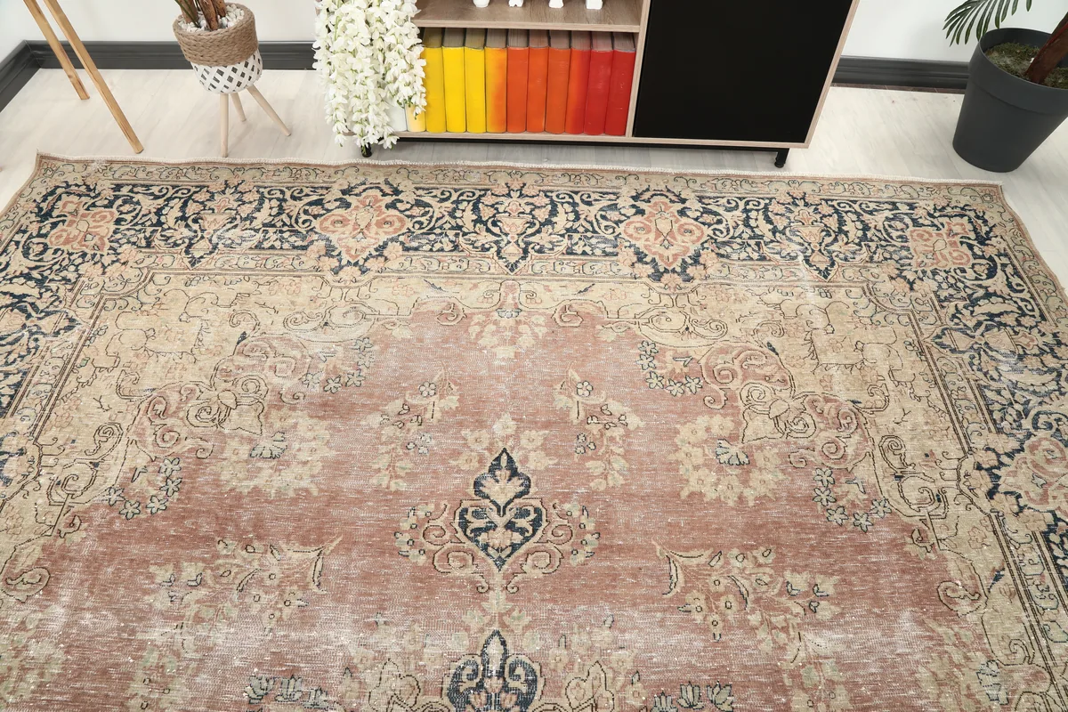 Angled view of the Faded Rose Navy Medallion Floral Rug, showing the full width of the rug and border patterns.