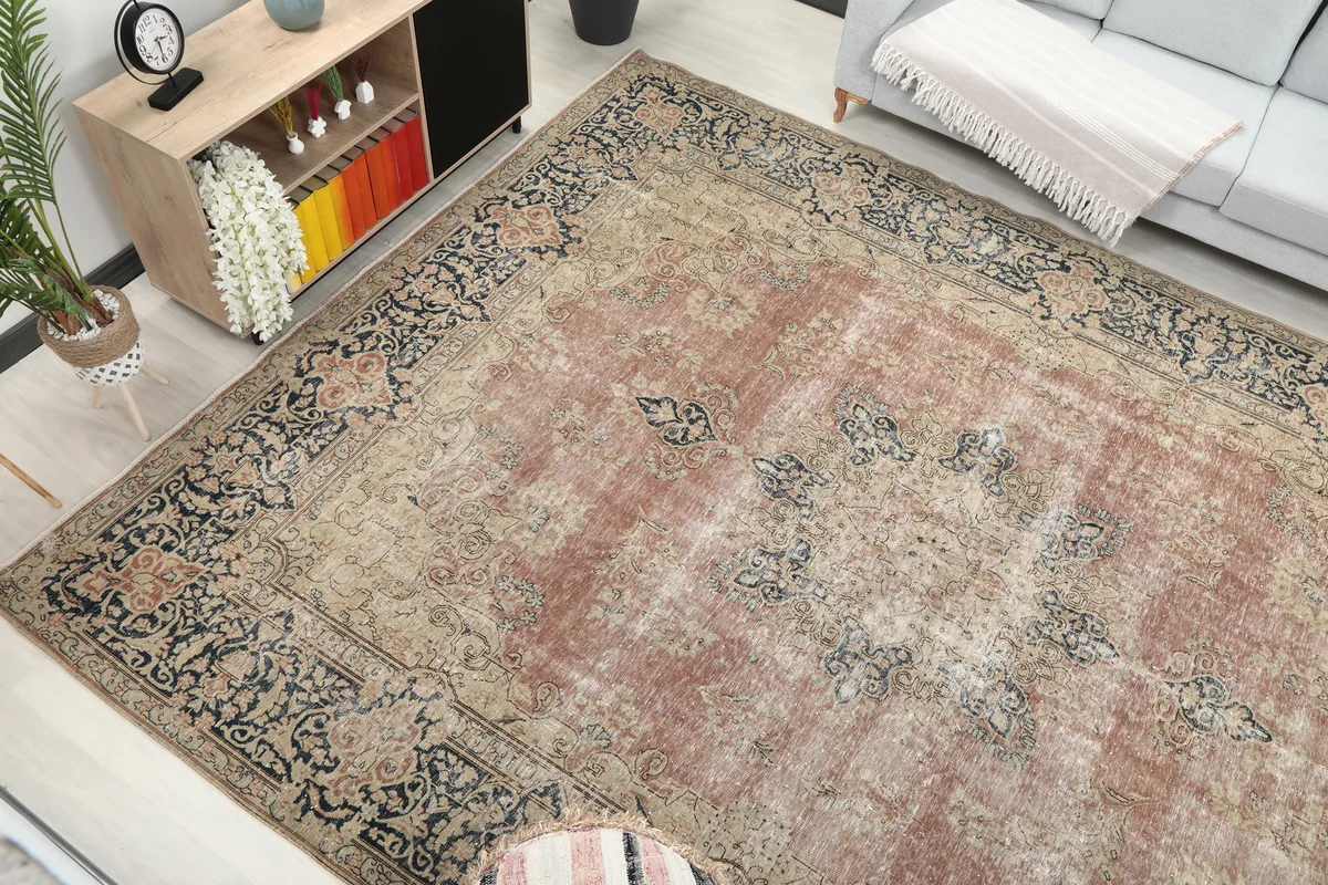 Angled view of the Faded Rose Navy Medallion Floral Rug, focusing on the interplay of rose, navy, and beige tones.