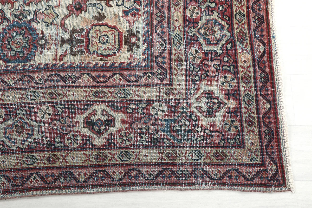 Close-up detail of the Cream Rose Floral Anatolian Rug's corner, showing border patterns and color variations