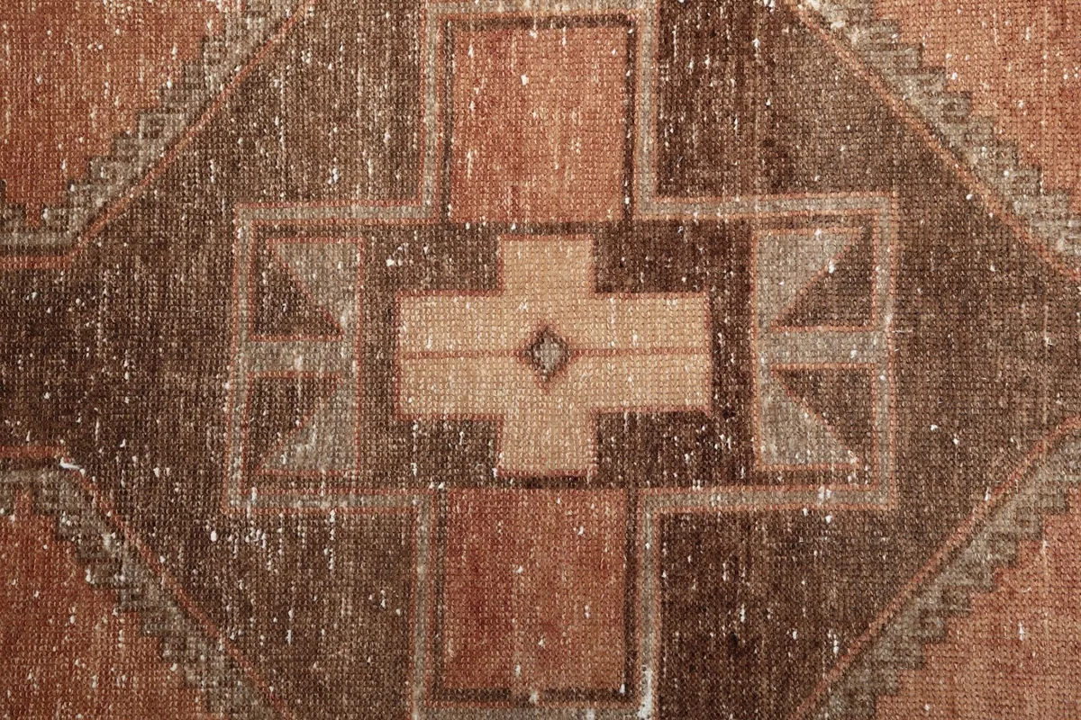 Close-up of the low wool pile, revealing the hand-knotted texture and color variations of the vintage rug.