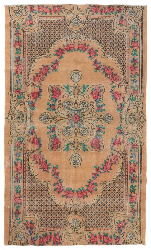 Full top view of the orange and rose floral vintage Anatolian rug on a white background.