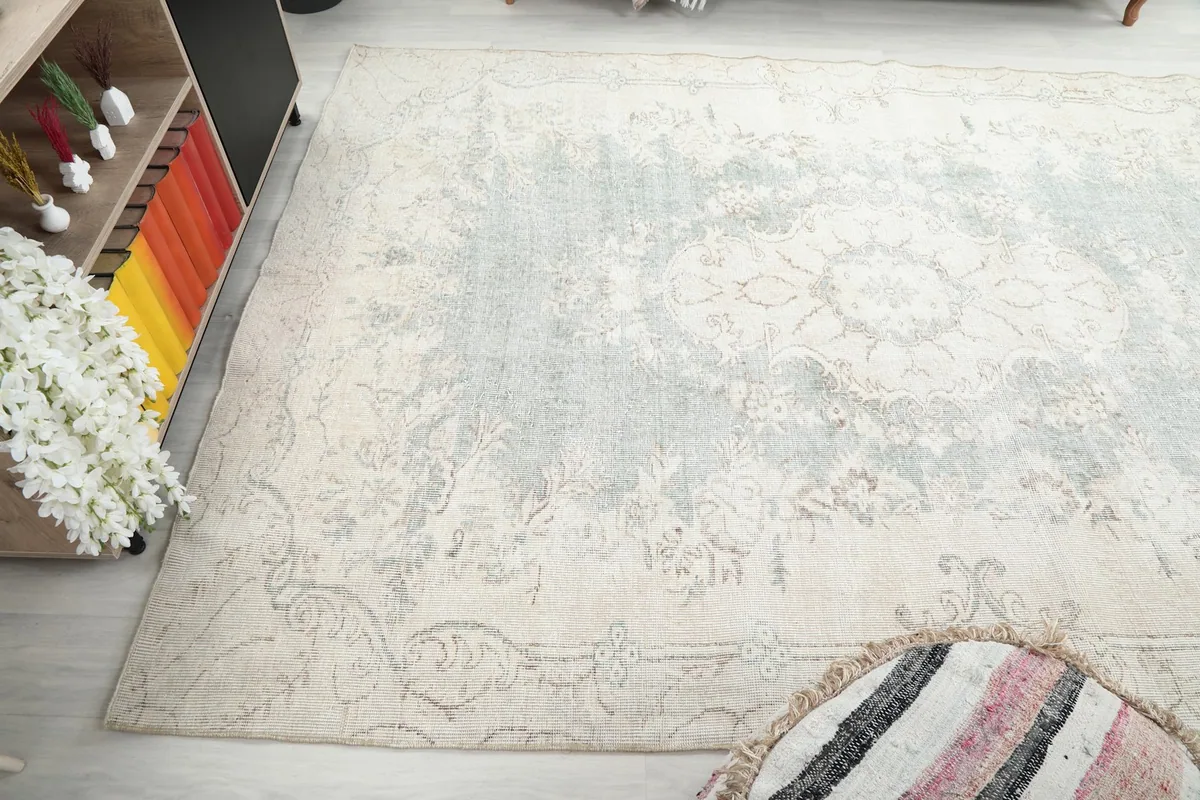 Angled shot of the rug's corner and border, illustrating its faded appearance