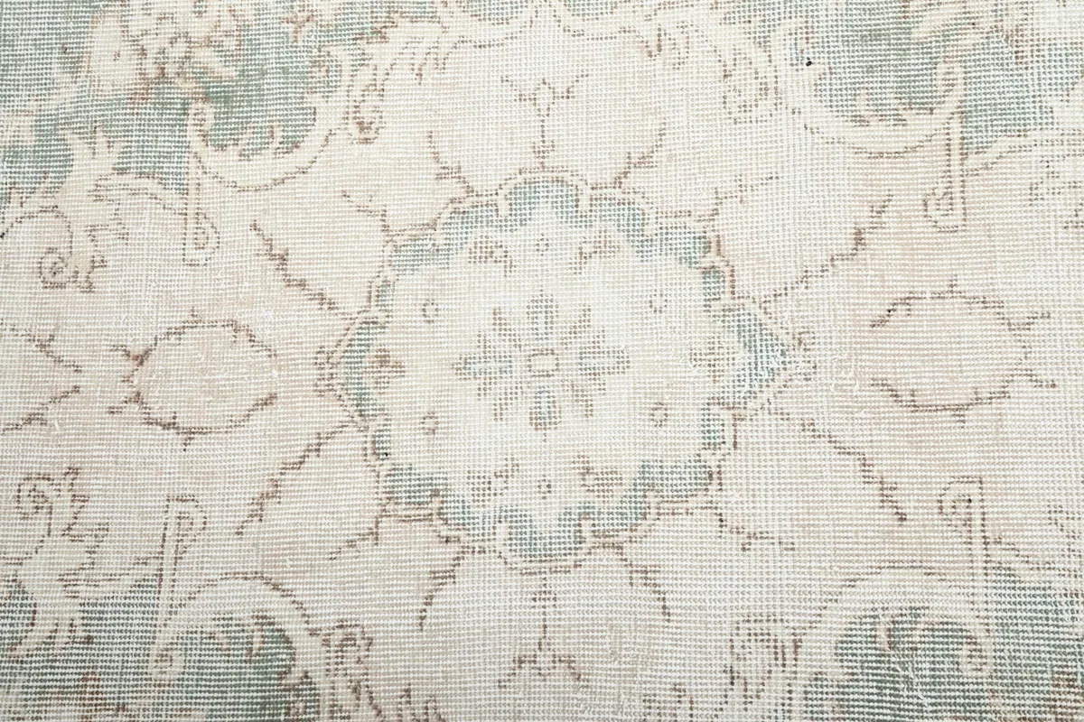Close-up of the central medallion design, highlighting the subtle blue and cream tones