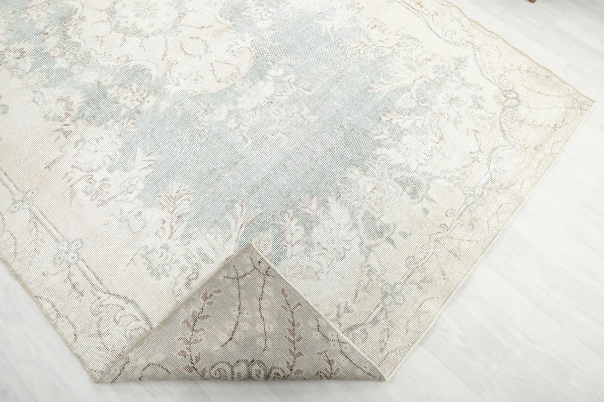 Corner of the rug folded back to show the hand-knotted cotton foundation