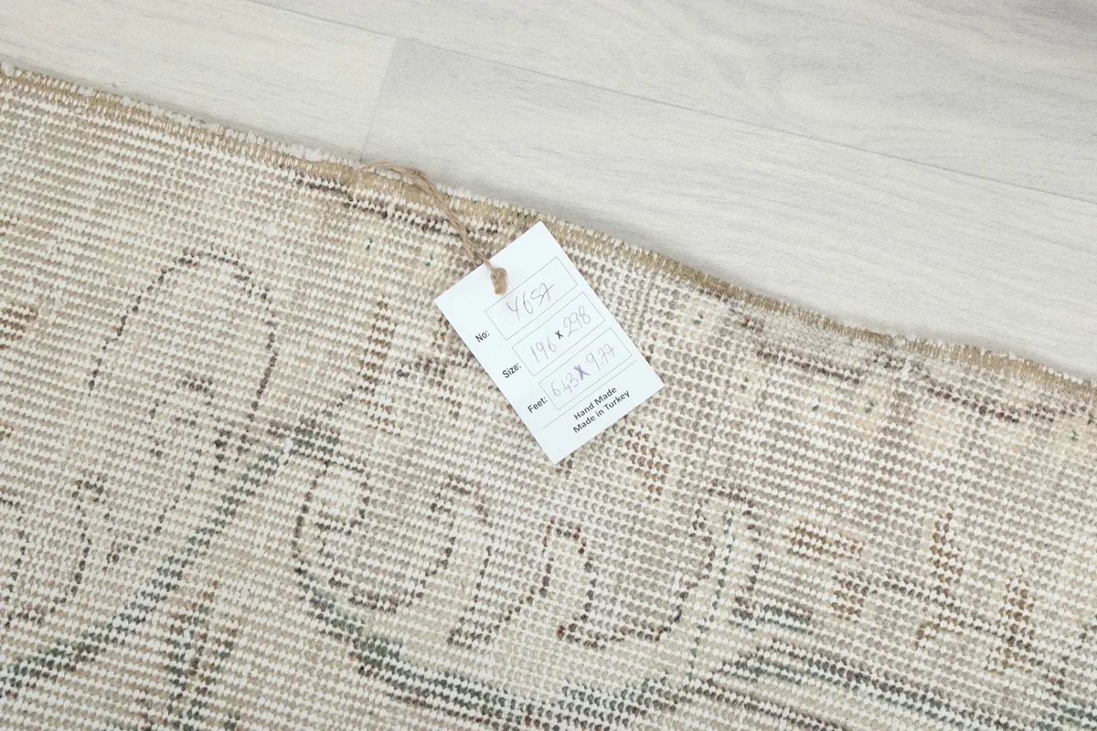Rug's edge with a product tag displaying details and dimensions