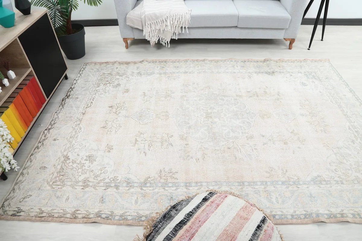 Wide angled shot of the rug in a room, capturing its overall size and muted aesthetic.