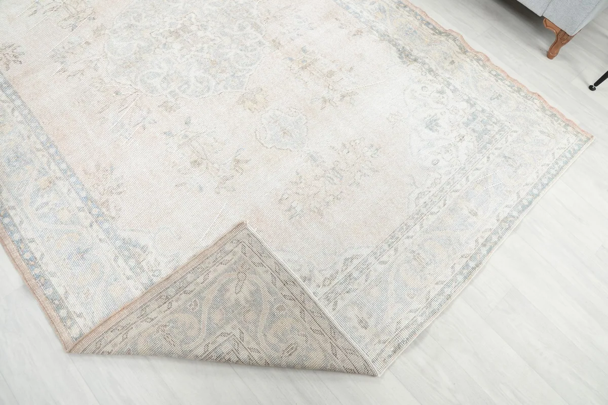 Corner of the rug folded back to reveal the cotton foundation and hand-knotted construction.