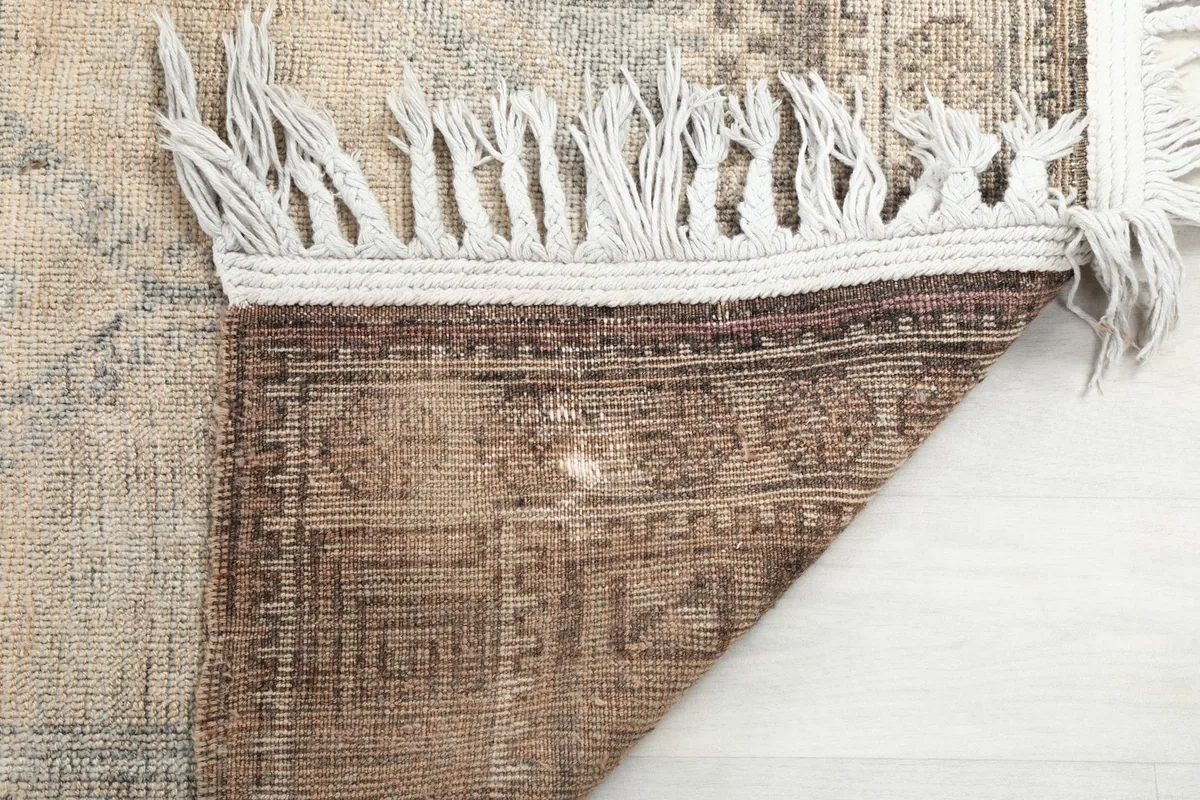 Close-up of the rug's back, showing the tightly woven cotton foundation and knotting