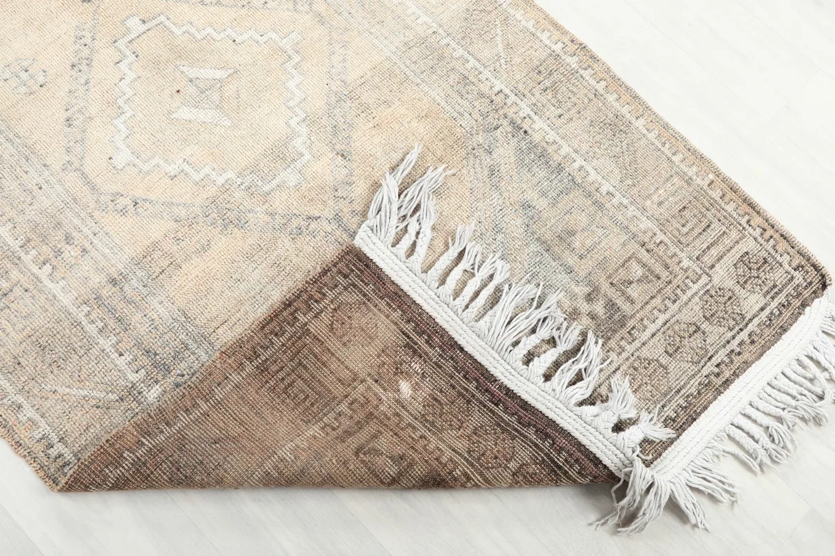 Rug folded to reveal the cotton foundation and the reverse side of the hand-knotted pile