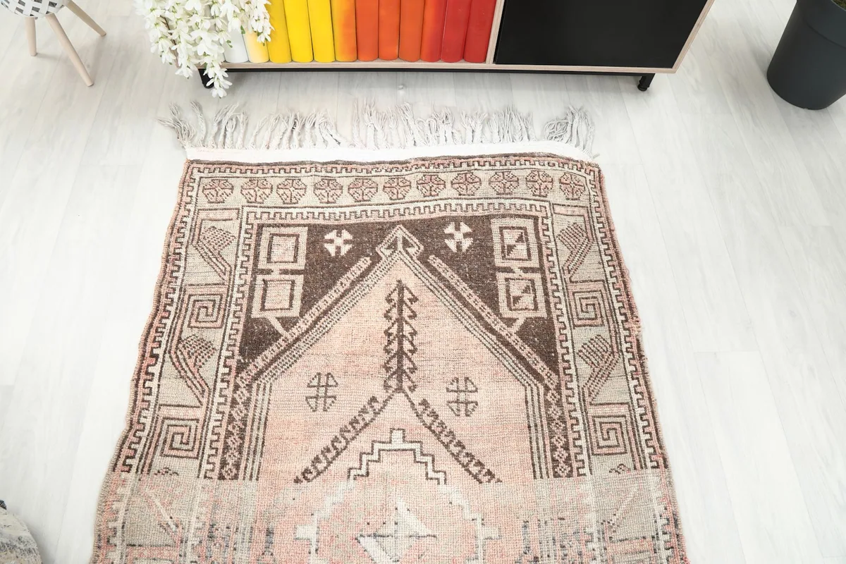 Overhead view of the rug's end section, showcasing the darker brown and beige patterns