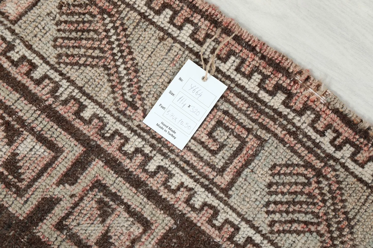 Close-up of the rug's label attached to the fringe, showing details of origin and material