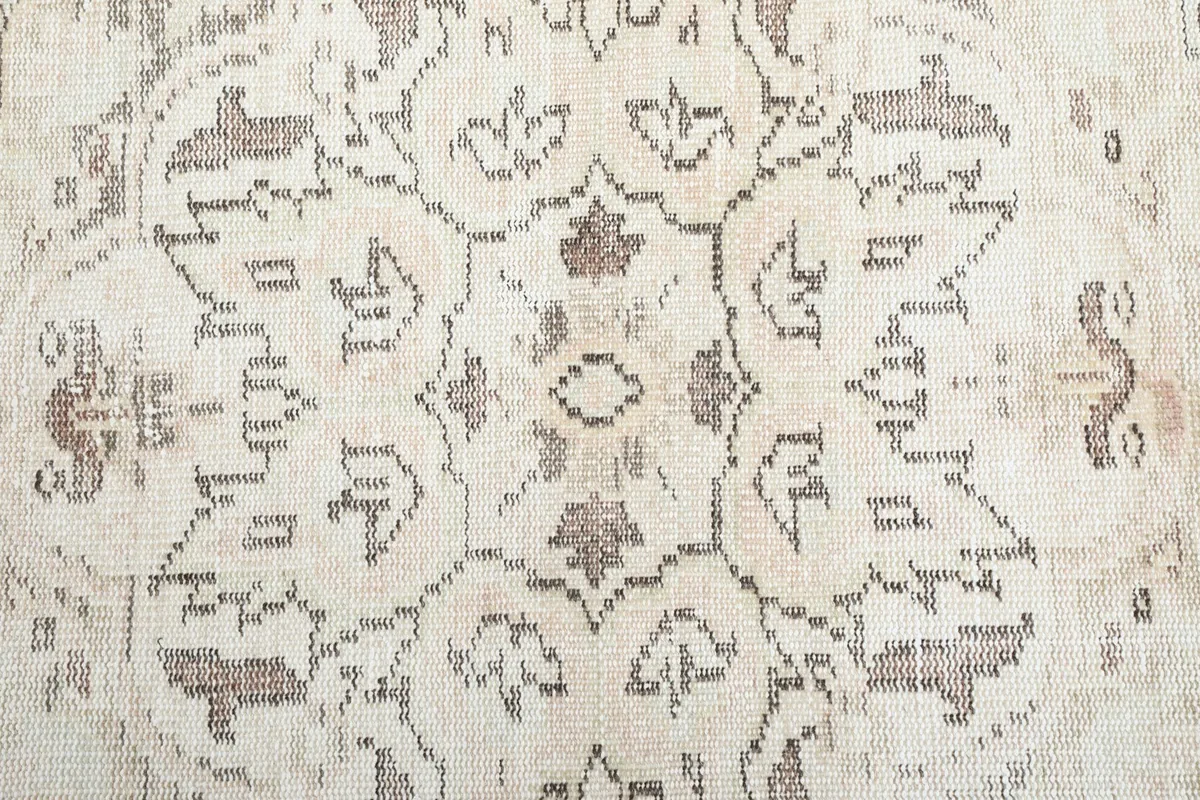 Macro detail of the central floral medallion showing the hand-knotted texture and coloration