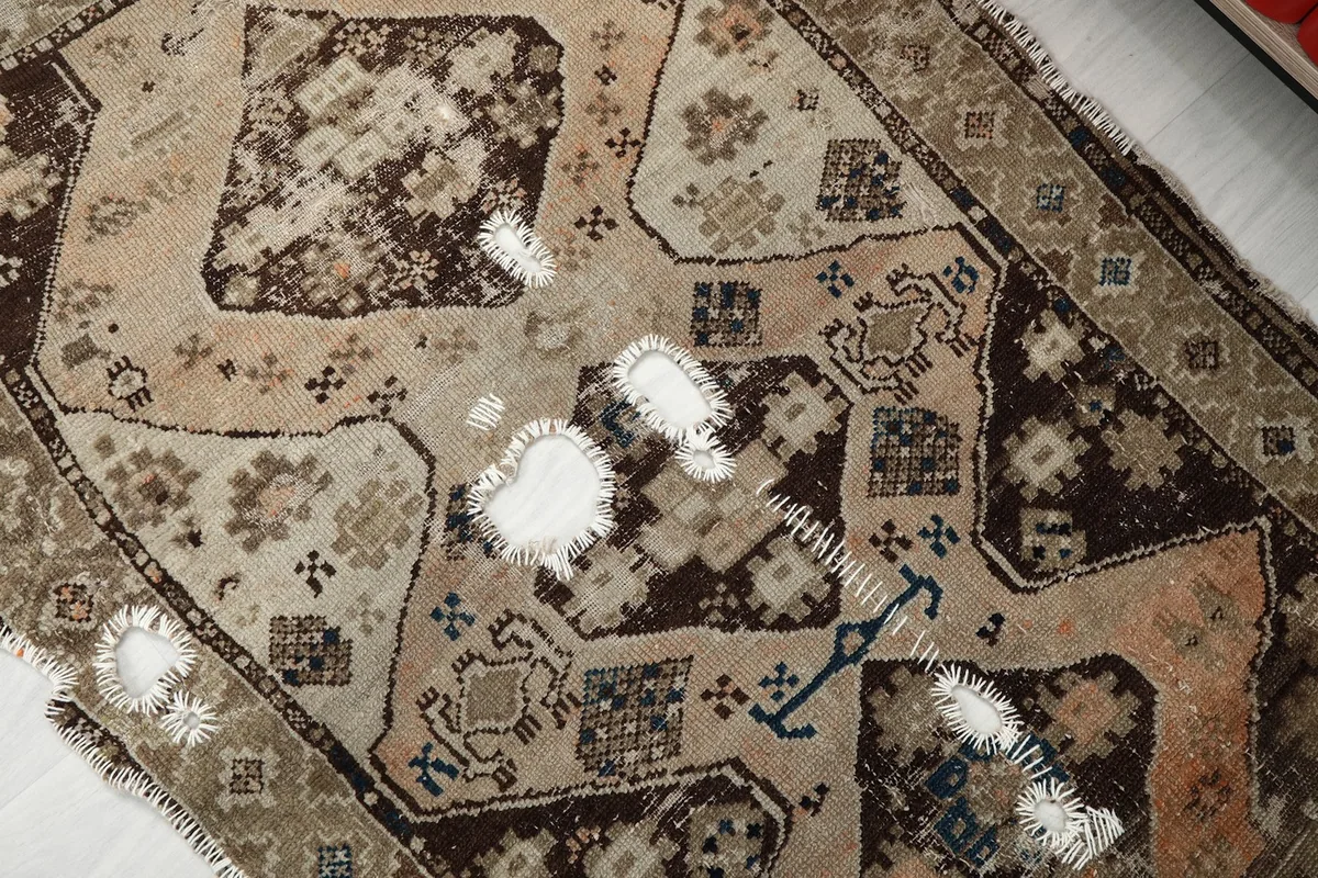 Detailed view of the central medallion and surrounding patterns, highlighting areas of wear and visible cotton